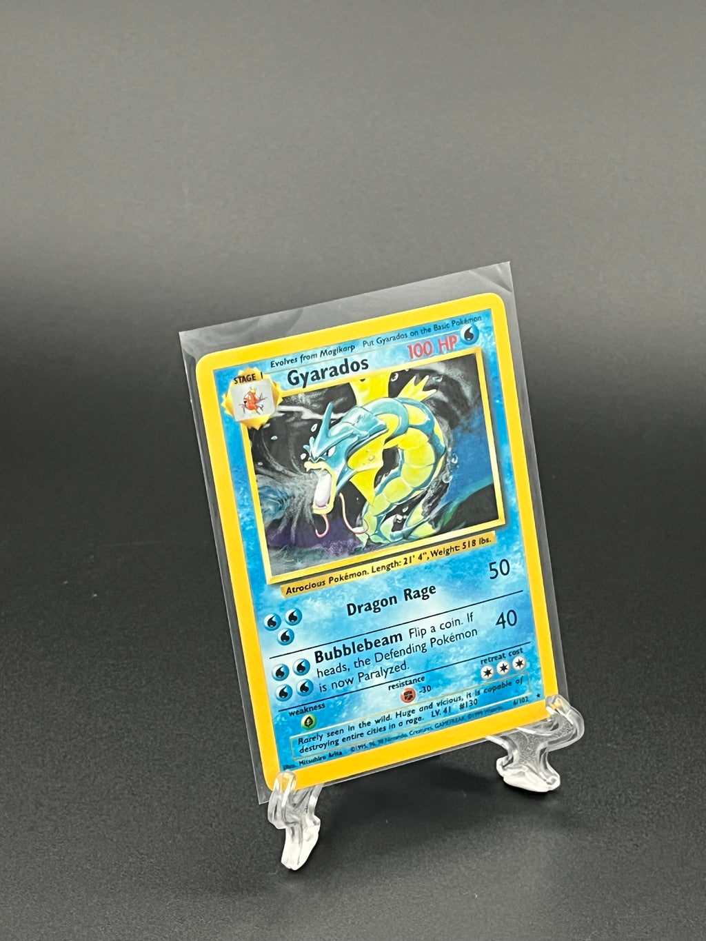 Trading card in a clear protective sleeve on a dark background