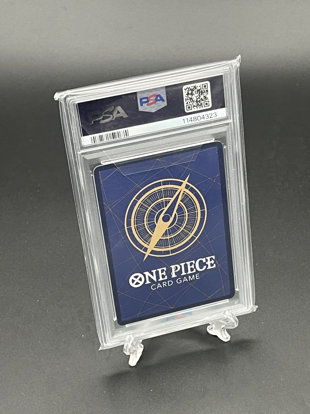 One Piece card game card in a PSA holder on a gray background