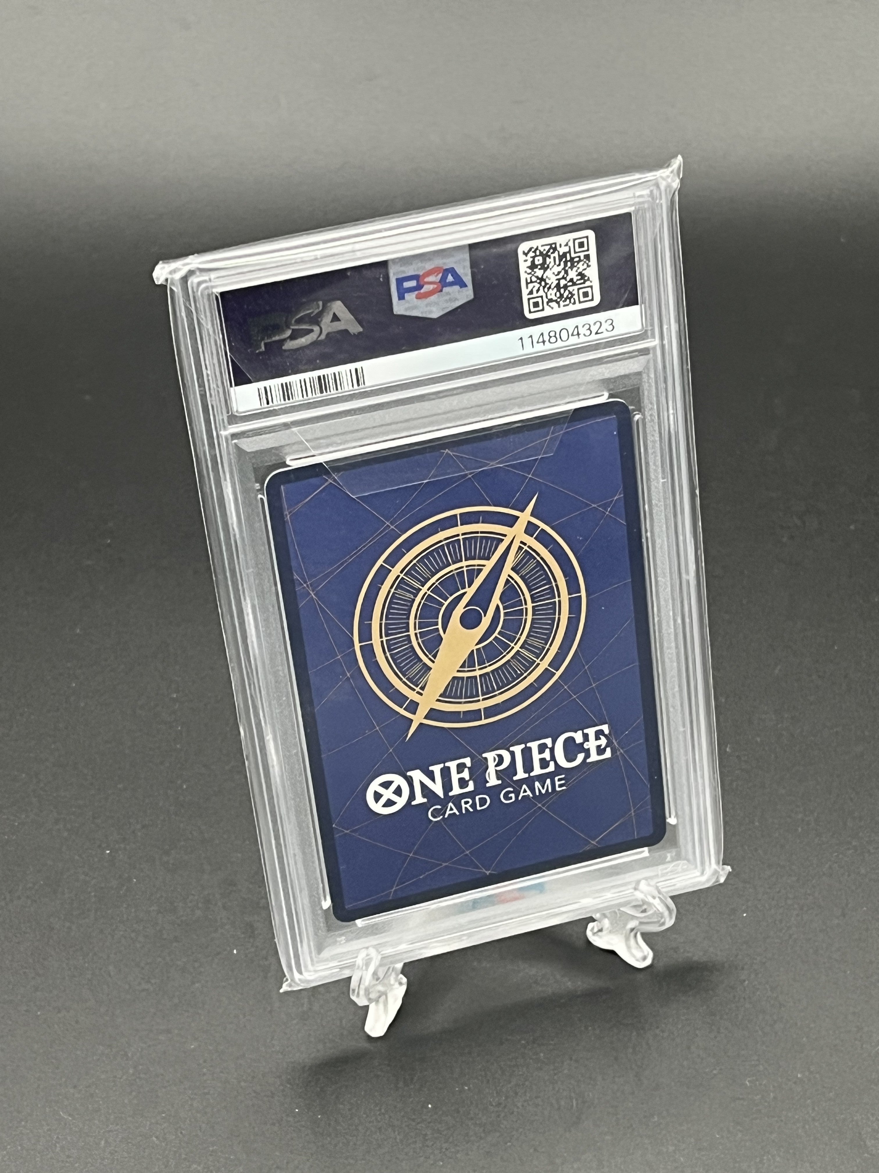 One Piece card game card in a PSA holder on a gray background