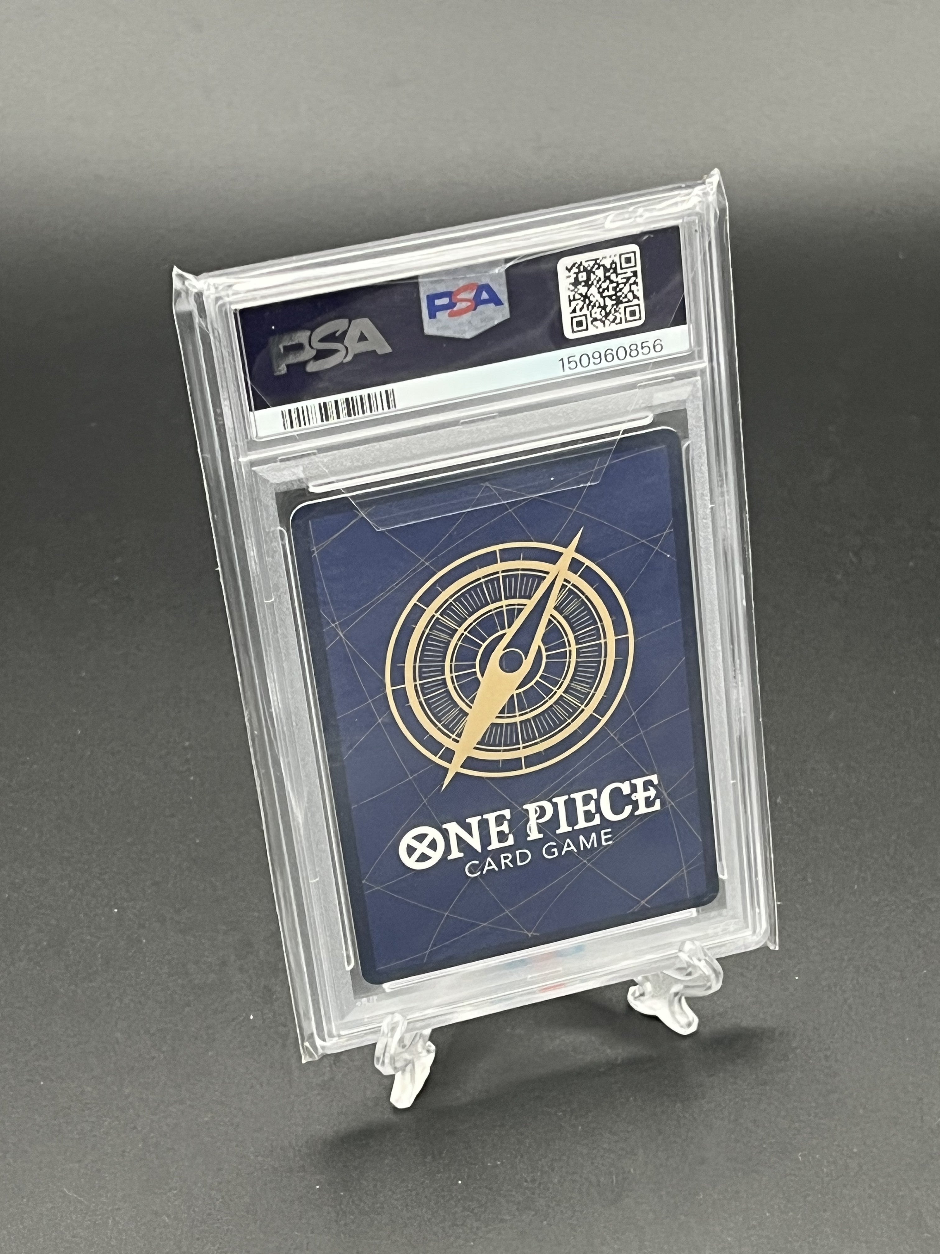 One Piece card game card in a PSA holder on a gray background