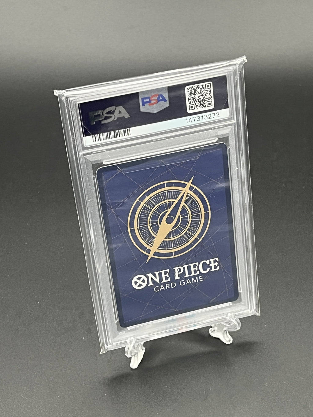 One Piece card game card in a PSA holder on a gray background