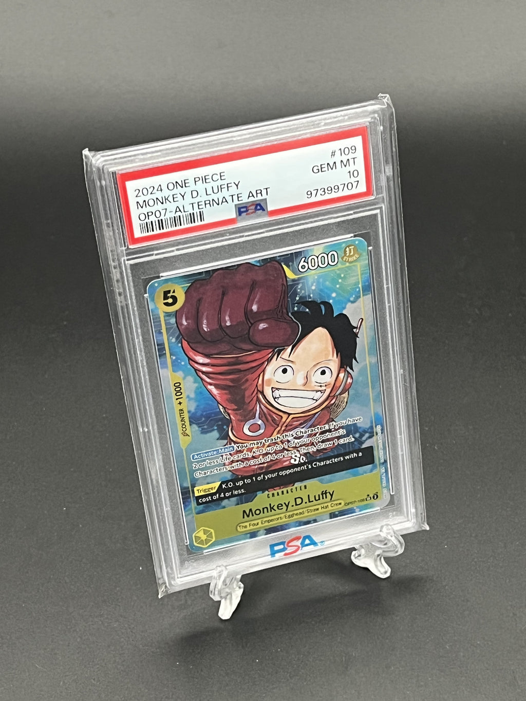 Trading card of Monkey D. Luffy from One Piece in a protective case on a gray background