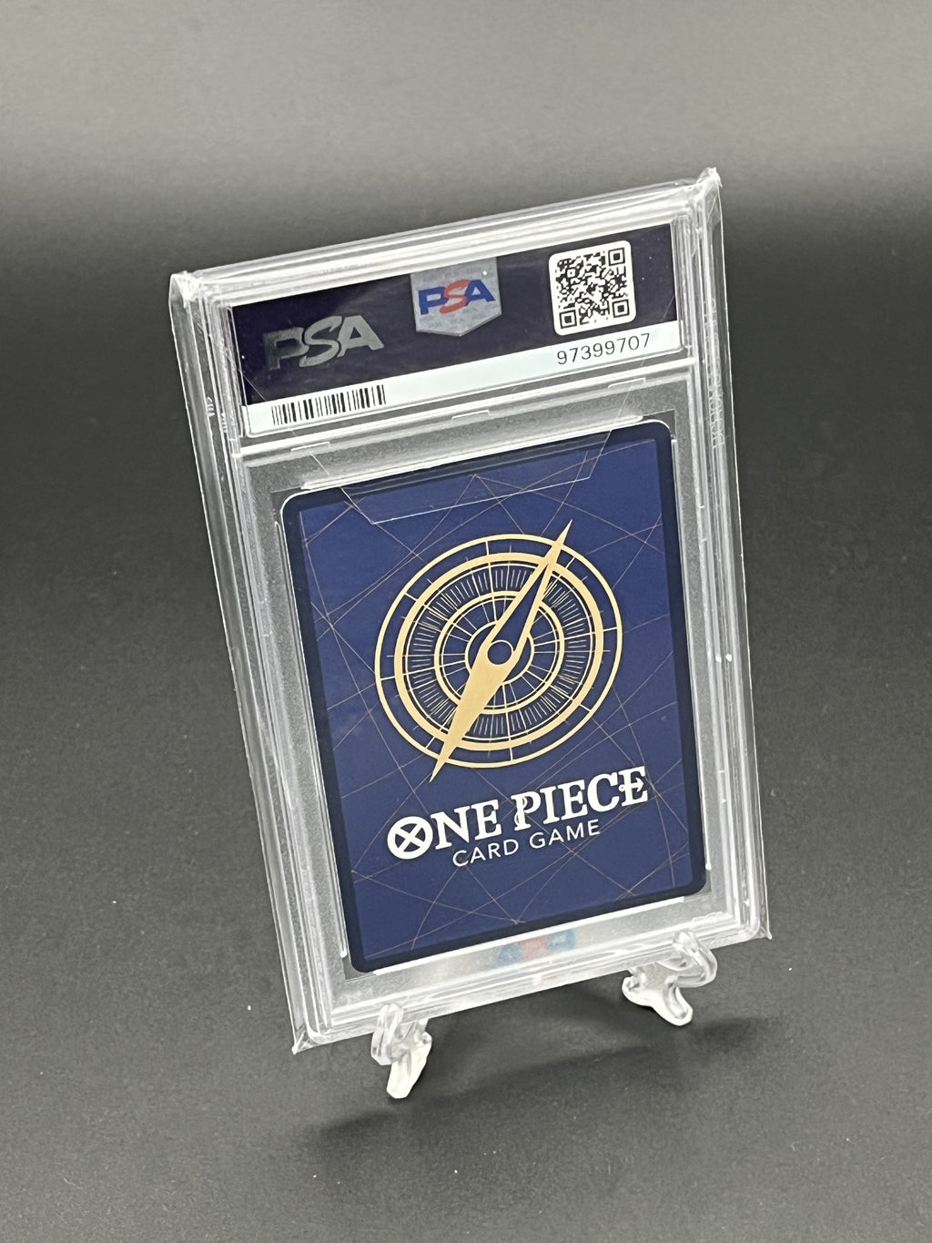 One Piece card game card in a PSA holder on a gray background