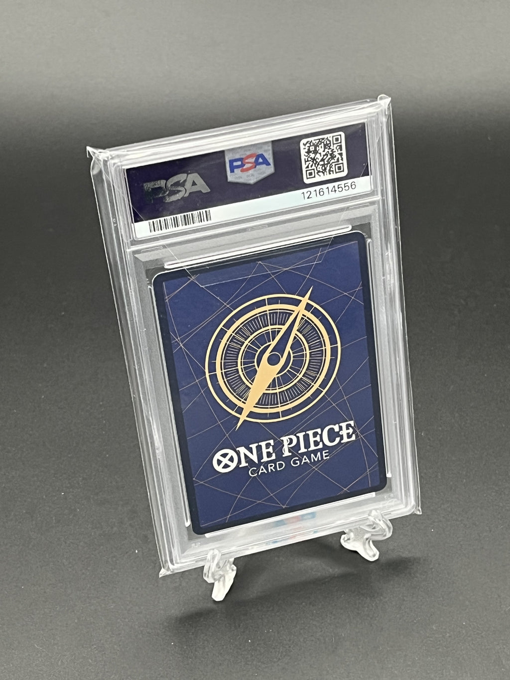 One Piece card game card in a PSA holder on a gray background