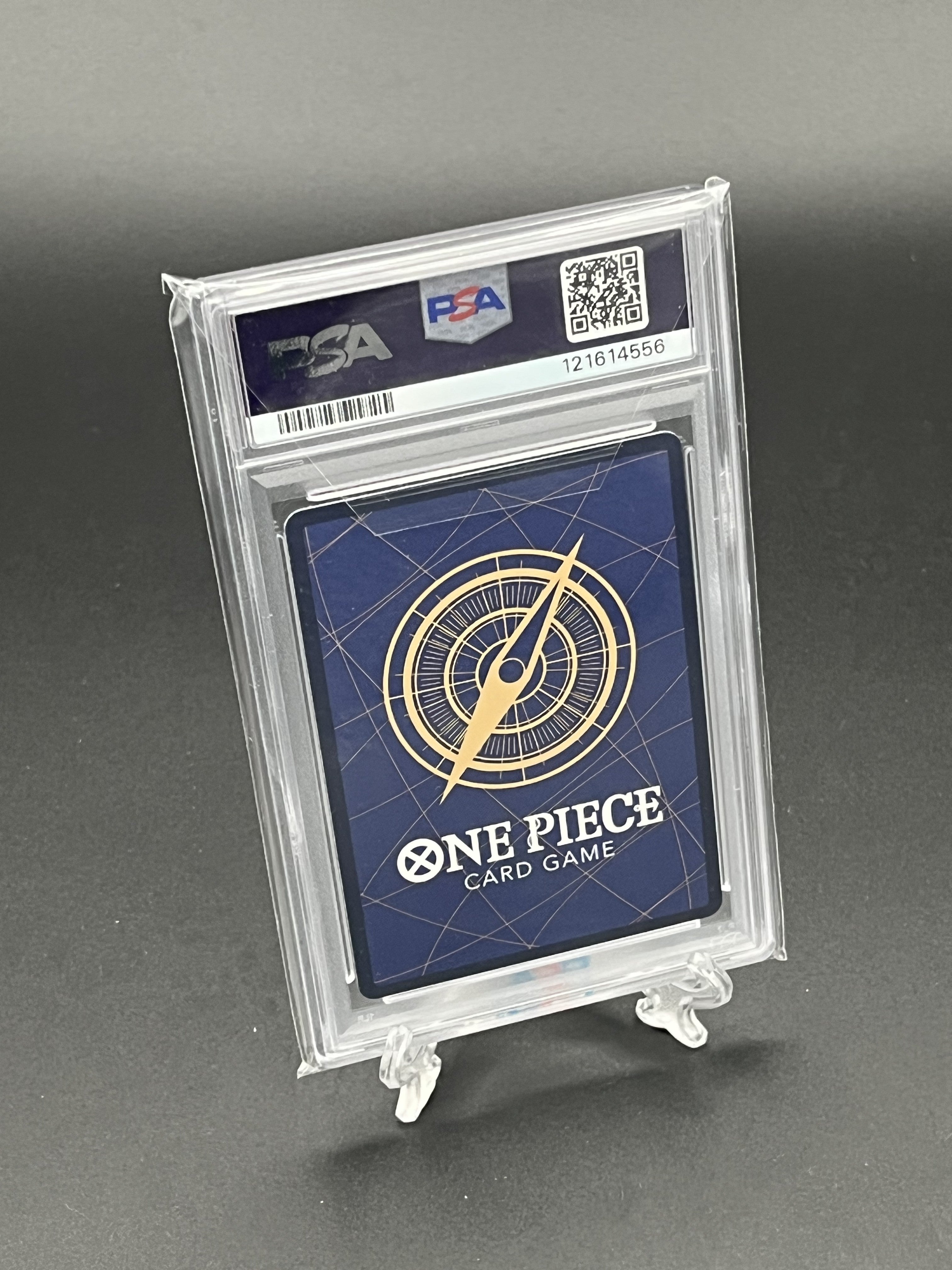 One Piece card game card in a PSA holder on a gray background